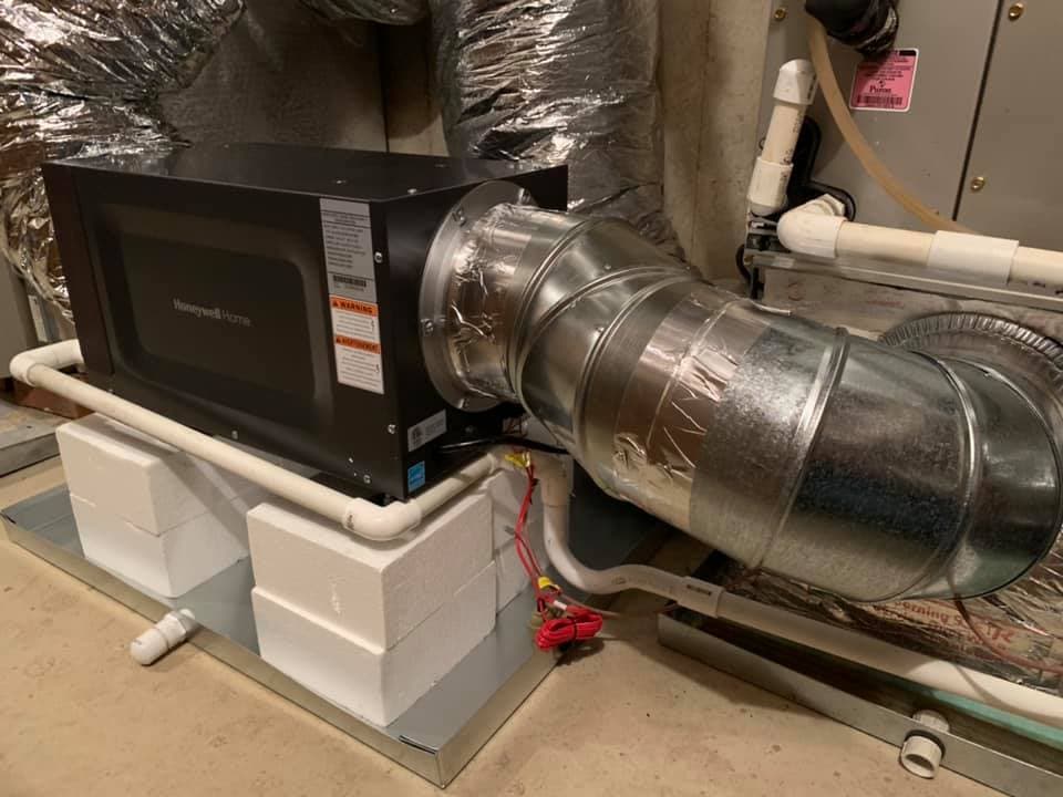 Thermal HVAC technician installing an indoor air quality system in Lawrenceville, GA